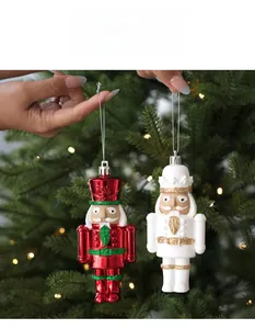 Detail von roten und weißen Nussknacker-Soldaten-Anhängern mit Glitzer am Weihnachtsbaum