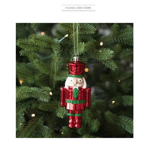 Detailansicht eines rot-grünen Nussknacker-Anhängers an einem festlichen Weihnachtsbaum