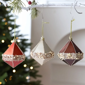 Three elegant octahedron Christmas ornaments with pearls and sequins on white branches