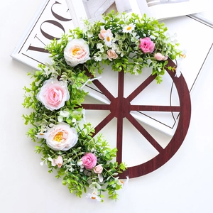 Vintage wooden wheel wreath with artificial roses and pine cones for Christmas home decor