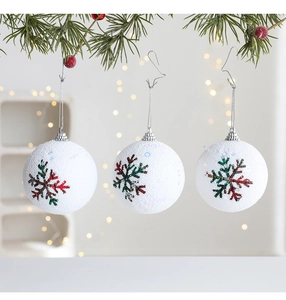 Detalle de bolas de Navidad blancas esmeriladas con copos de nieve colgadas en una rama