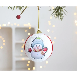Primer plano de una bola de Navidad blanca con dibujo de muñeco de nieve en un abeto