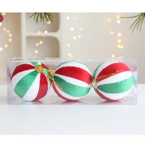 Detalle de tres bolas de Navidad de terciopelo con espirales rojas y verdes en caja transparente