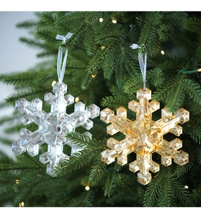 Close-up of sparkling crystal snowflake ornaments with white ribbons on a Christmas tree