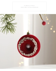 Dettaglio di pallina di Natale in velluto rosso con paillettes su ramo di pino