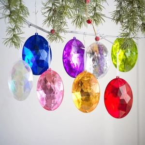 Set de 8 adornos de gemas acrílicas de colores colgados en una rama de árbol de Navidad