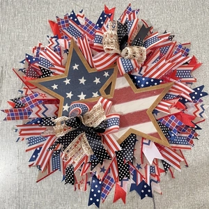 Detail of patriotic American flag ribbon wreath with rustic wooden stars and mesh bows