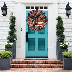 Patriotic Independence Day wreath with red white blue stars and ribbons on front door