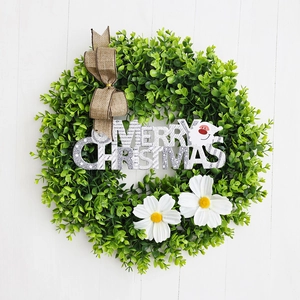 Detail view of eucalyptus Christmas wreath with Merry Christmas sign and linen bow tie