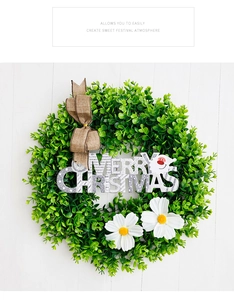 Detailed view of eucalyptus wreath with burlap bow and Merry Christmas silver glitter sign