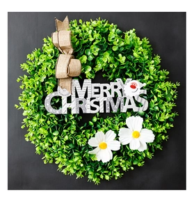 Close-up of artificial eucalyptus wreath with Merry Christmas sign and burlap bow