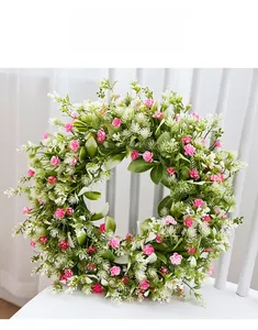 Detailed view of artificial floral wreath with pink flowers on a white wooden chair