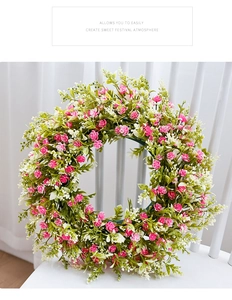 Detail of pink and white faux flowers on a lush spring wreath hanging on a white chair