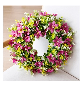 Detail view of pink lilies and green leaves on a spring wreath for front door decor