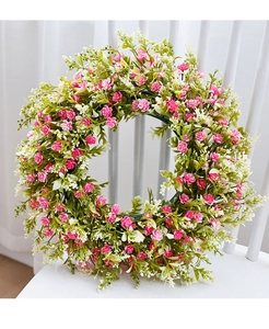 Close-up of spring daisy wreath with pink and white flowers on a white wooden chair