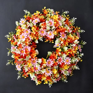Lebendiger Eukalyptuskranz mit rosa Gänseblümchen und bunten Blättern auf schwarzem Grund