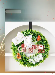 Detail of Christmas wreath with a white bow, gold reindeer motifs, and Merry Christmas sign
