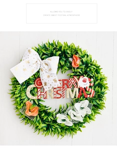 Detail of green Christmas wreath with Merry Christmas sign and golden reindeer bow