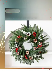 Détail macro d'une couronne de Noël en PE avec pommes de pin et baies rouges sur base verte