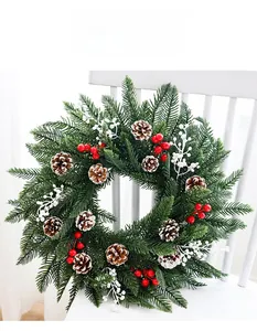 Détail de couronne de Noël en PE avec pommes de pin, baies rouges et branches blanches