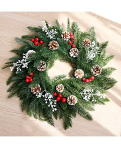 Détail d'une couronne de Noël en PE avec des pommes de pin et des baies rouges sur bois