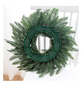 Vue détaillée d'une couronne de Noël en PE avec aiguilles denses et support de fixation