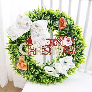 Artificial Christmas wreath with a white reindeer bow and Merry Christmas sign