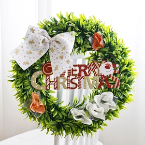 Artificial Christmas wreath with green foliage, large white bow and Merry Christmas sign