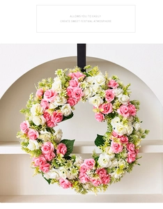 Détail d'une couronne de roses roses et blanches avec feuilles vertes sur ruban de soie