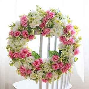 Couronne de roses artificielles roses et blanches décorative sur une chaise en bois