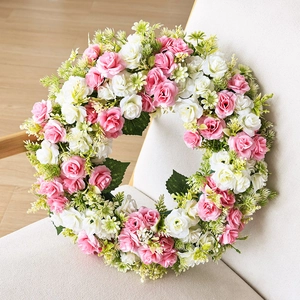Couronne de roses roses et blanches avec feuilles vertes pour porte et mur de maison