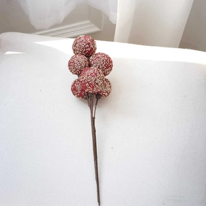 Close-up of artificial red berries with gold glitter for Christmas tree floral decor