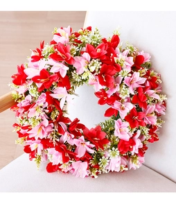 Close-up of artificial lily wreath featuring red and white flowers on a fabric chair