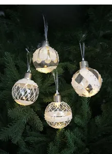 Close-up of four LED Christmas light bulbs with white patterns and glitter inside