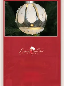 Close-up of a glowing glass Christmas ball with frosted snow patterns on a tree