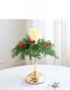 Nahaufnahme von Weihnachtskranz mit roten Beeren und goldenem LED-Kerzenständer-Detail