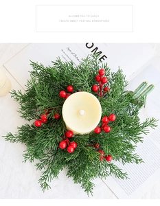 Nahaufnahme eines Weihnachtskerzenrings mit Tannennadeln und roten Beeren auf weißem Tisch