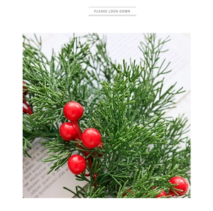 Detail von Weihnachts-Zeder-Zweigen mit glänzenden roten Beeren für festliche Deko
