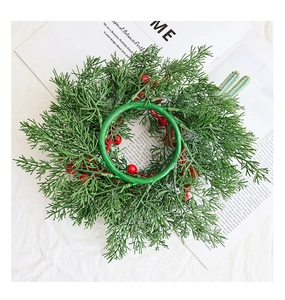 Detailansicht eines Weihnachtskranzes mit grünen Tannennadeln und roten Beeren auf Magazin