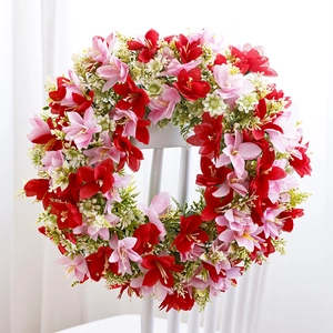 Spring wreath with red and pink faux flowers on a white chair for home wall decor