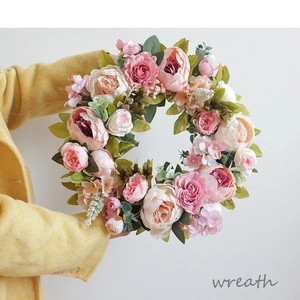 Close-up of a handmade silk peony flower wreath being held by a model for sizing