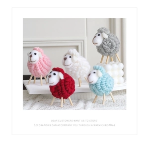 Detailed close-up of handmade wool felt sheep figurines in five colors for Christmas decor