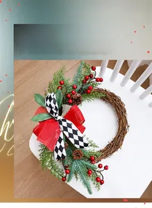 Detail of a rustic Christmas wreath with red berries, pine cones and a checkered bow