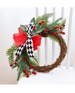 Close-up of Christmas wreath with red berries and pine cones on a white chair