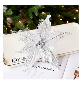 Gros plan d'une fleur de Noël artificielle argentée avec paillettes et baies