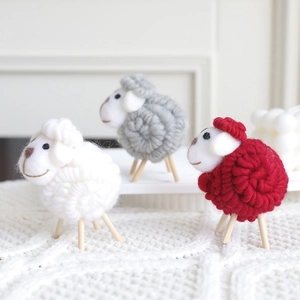 Three handmade wool felt sheep ornaments with wooden legs for Christmas home decoration