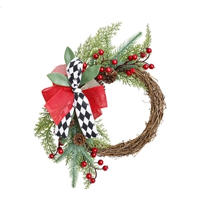 Christmas wreath with red berries, pine cones and buffalo plaid bow on wood grapevine