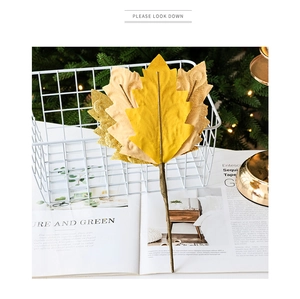 Detail of artificial golden leaves branch with glitter finish for Christmas DIY decor