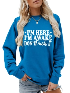 Detail of blue crewneck sweatshirt featuring white I'M HERE I'M AWAKE graphic text print