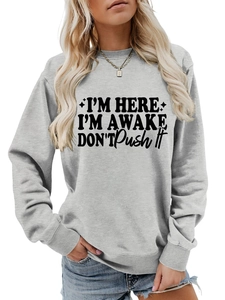 Detail of grey crewneck sweatshirt featuring black I'M HERE I'M AWAKE typography